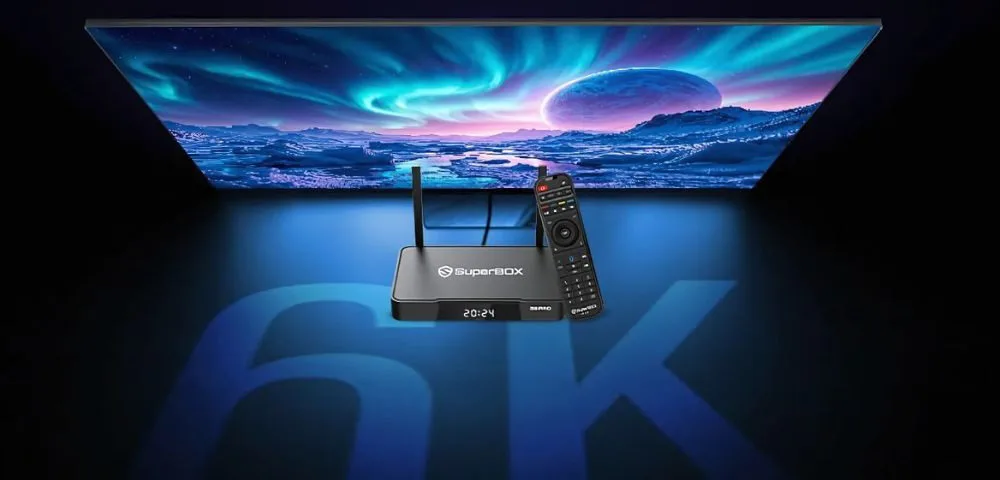 SuperBox S7 streaming device with remote control displayed in front of a 6K TV screen featuring a vibrant cosmic landscape.